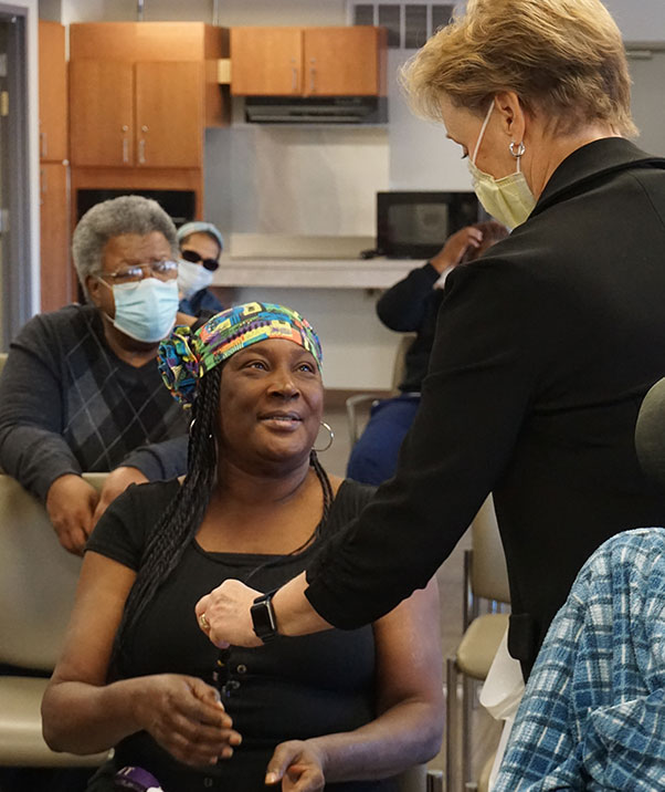 Park Tower resident smiles and interacts with a PCOM faculty member during a Healthy Aging presentation