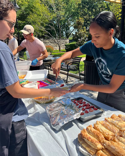 PCOM student serving foor at "Eat Around Latin America" event