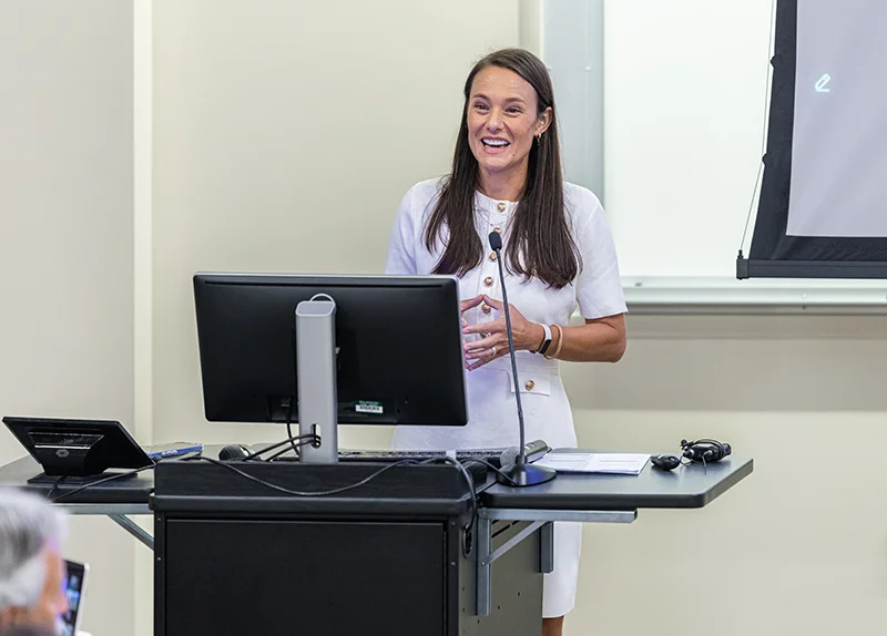 Nikki Schultek, Co-Founder and Executive Director of AlzPI and Founding Director of the PCOM Pathobiome Research Center smiles as she speaks during the event