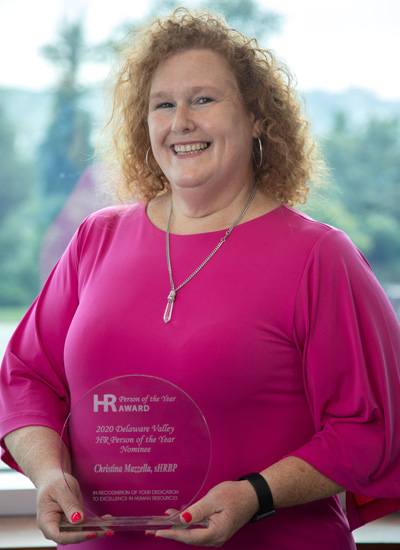 Headshot photograph PCOM Chief Human Resources Officer Christina Mazzella, MS, smiling and holding her award