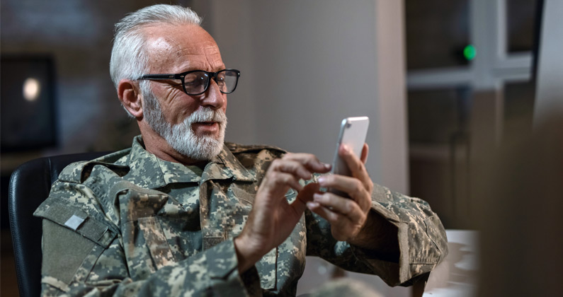 Philadelphia veteran uses a cell phone to talk to a PCOM medical student in a patient history interview assignment.