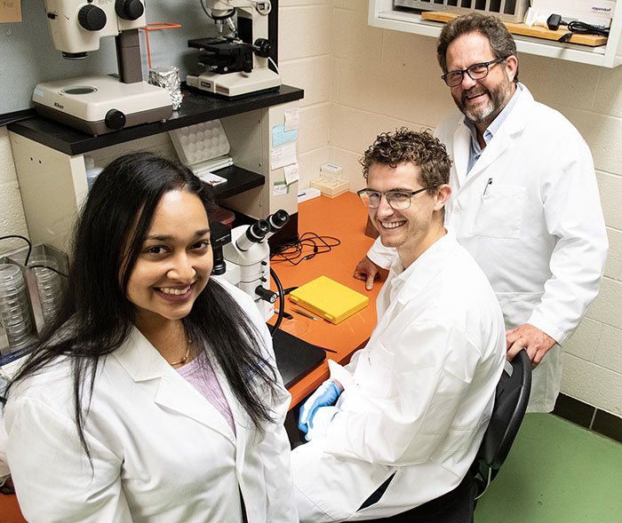 Dr. Bravo Nuevo works with latino graduate students in a PCOM research lab