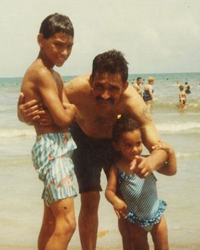 Leslie Fernandez as a child with her late father and brother on a beach in Puerto Rico