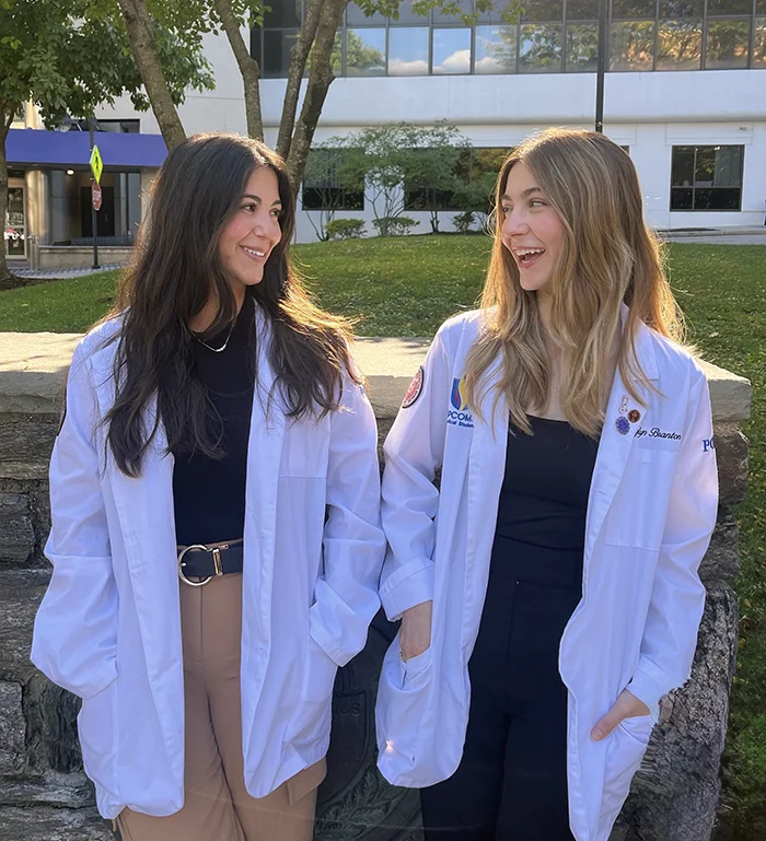 PCOM DO students and sisters Kaylyn and Megan Branton laugh and look at each other during a photo shoot