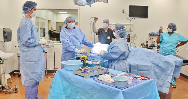 PCOM students and faculty wear masks, gloves and gowns during medical scenarios in the Simulation Center.