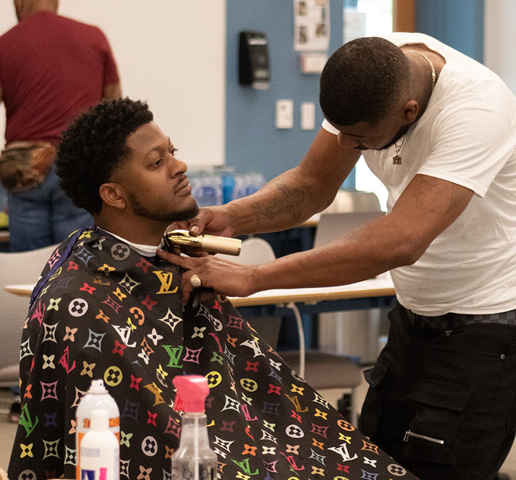 PCOM South Georgia med students talks with locals in a Moultrie barber shop