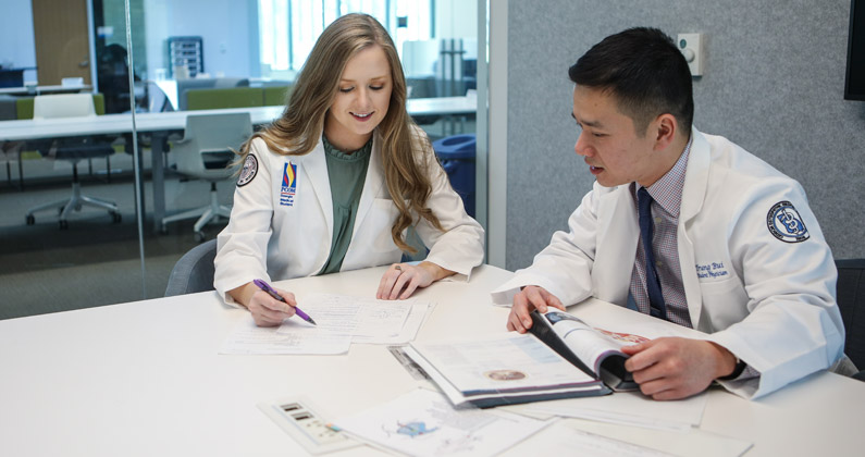 Two PCOM South Georgia medical students engage in a stressful study session in the library.