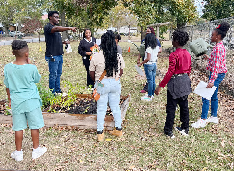 PCOM South Georgia student physician Emeka Ikeakanam (DO ’26), quizzes Boys & Girls Club members known as the Garden Club.