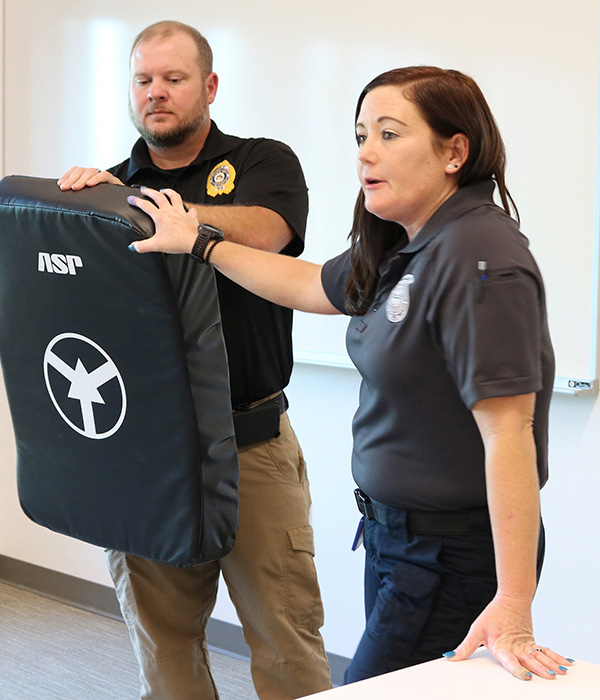 Browning and her husband in a classroom teaching a self defense class