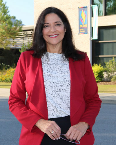 Dr. Golden stands outside on a sunny day in front of the PCOM South Georgia campus