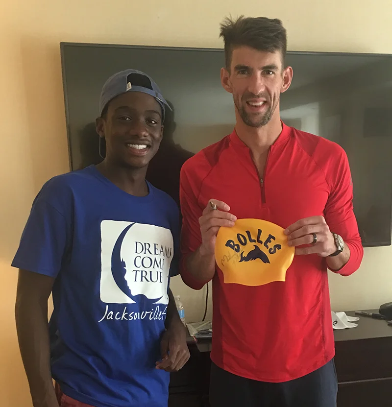 Rian Covington (DO '30) poses for a photo with Olympic swimmer Michael Phelps