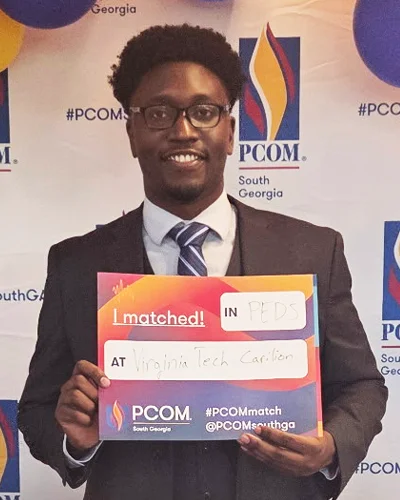 Emeka Ikeakanam (DO ’26) holds a Match Day sign