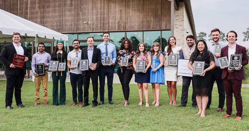 PCOM South Georgia students gather outside and pose with awards