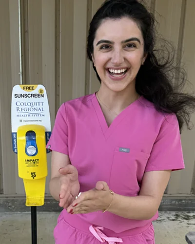 Darya Khani (DO ’26) demonstrates how to use the sunscreen dispenser