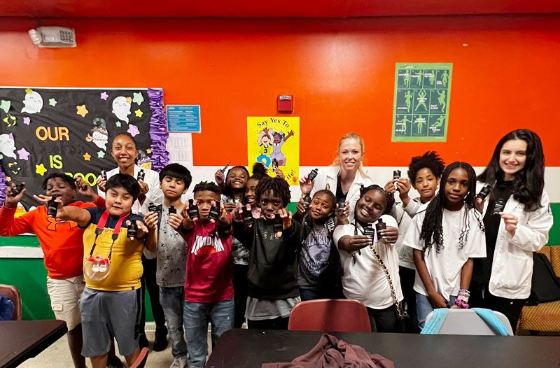 PCOM South Georgia Dermatology Club officers distribute sunscreen samples to members of the Boys and Girls Club