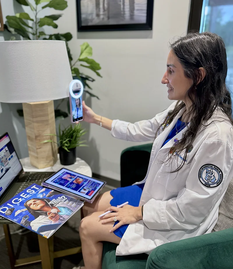 DO student Flora Heydari records a tiktok video on her phone at PCOM South Georgia's campus
