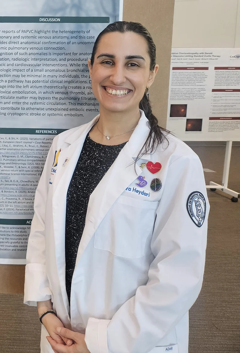 PCOM South Georgia medical student Flora Heydari (DO '29) smiling in front of her medical research poster