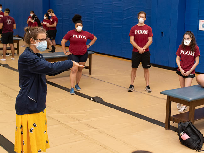 An OMM clinical scholar instructs a small group of med students during an OMM course at PCOM.