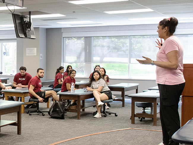 OMM faculty member lecturing students during an OMM lab course