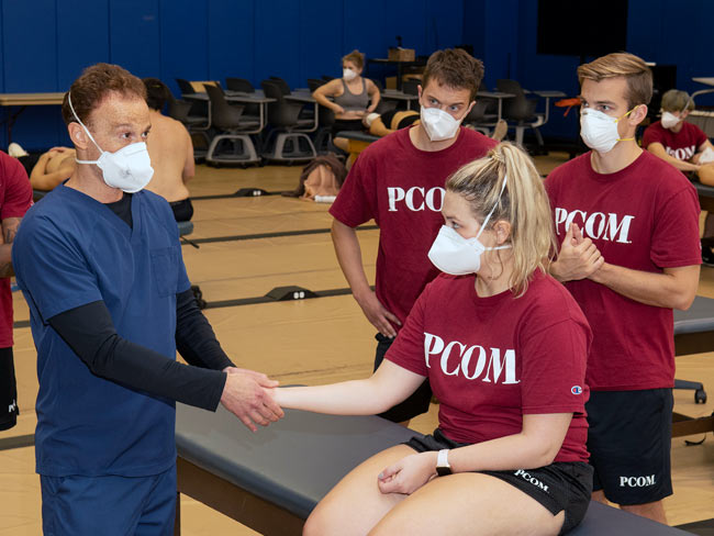 Dr. Levin demonstrating an OMM technique on a student's arm during a lab