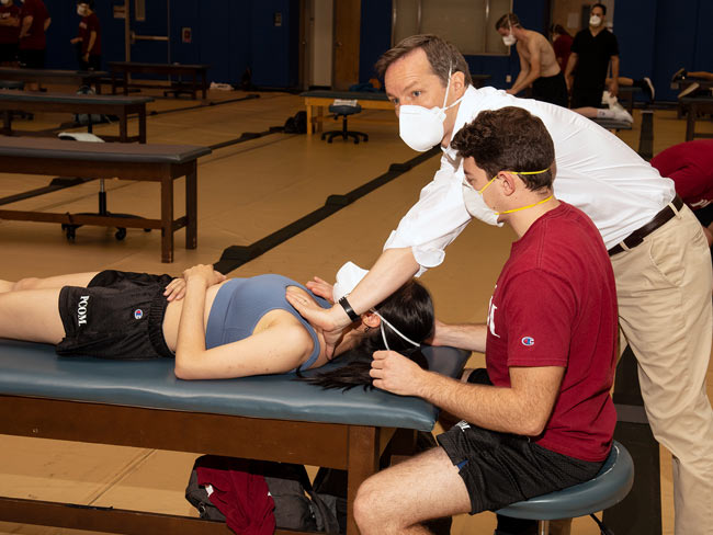 Dr. Allison demonstrates an OMM technique for osteopathic medcine students during a course