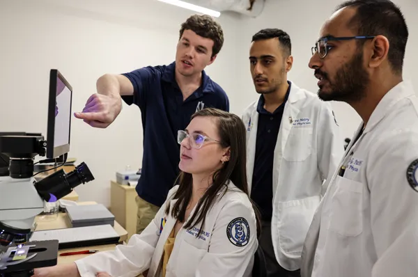 PCOM South Georgia biomedical sciences students look at imaging equipment in a laboratory