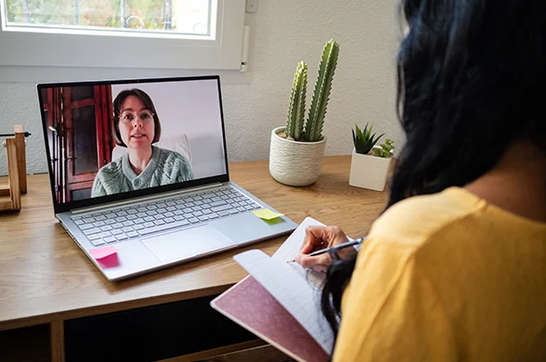 A prospective student attends PCOM's mental health counseling virtual information session on a laptop