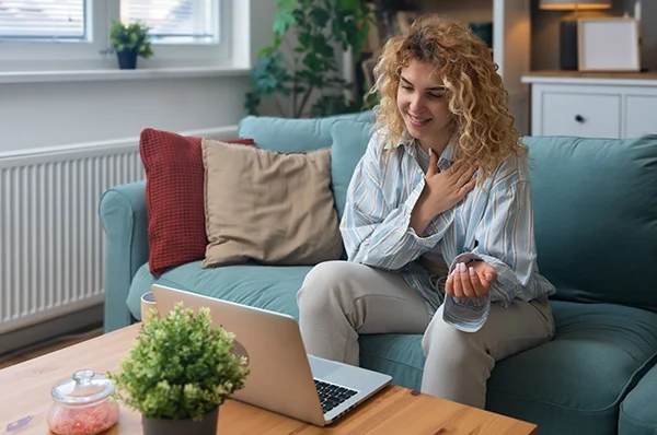 A college student attends PCOM's mental health counseling virtual information session on a laptop