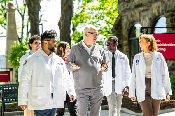 PCOM Doctor of Osteopathic Medicine students walking across the Philadelphia campus with Dr. Feldstein