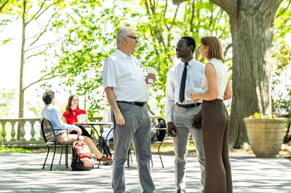 Graduate students speaking with an administrator outside during an open house event at PCOM
