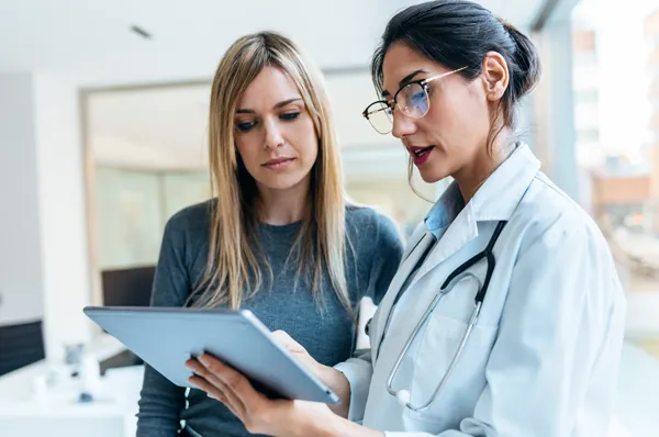 PCOM Doctor of Osteopathic Medicine student reviews chart with patient
