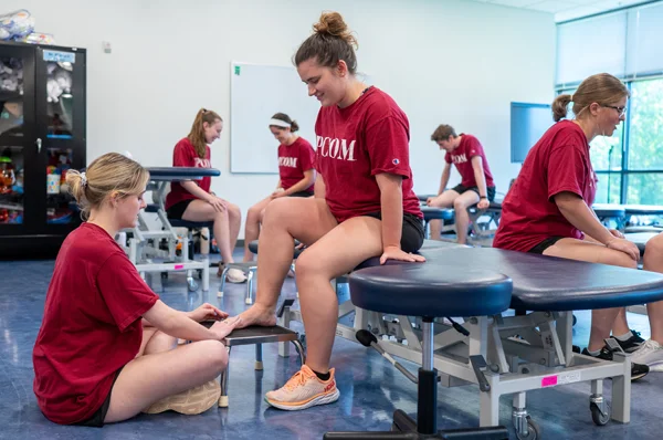 PCOM Georgia physical therapy students smile as they participate in hands-on learning exercises.
