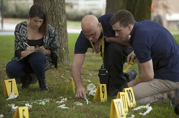 PCOM forensic medicine students and faculty investigate a mock crime scene during a hands-on field exercise