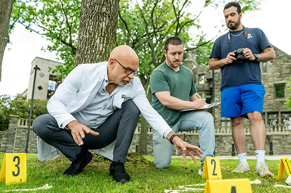 PCOM forensic medicine students and faculty work on a mock crime scene investigation during a field exercise on campus