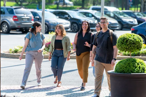 Graduate students giving a campus tour to prospective students while they walk and talk outside at PCOM Georgia