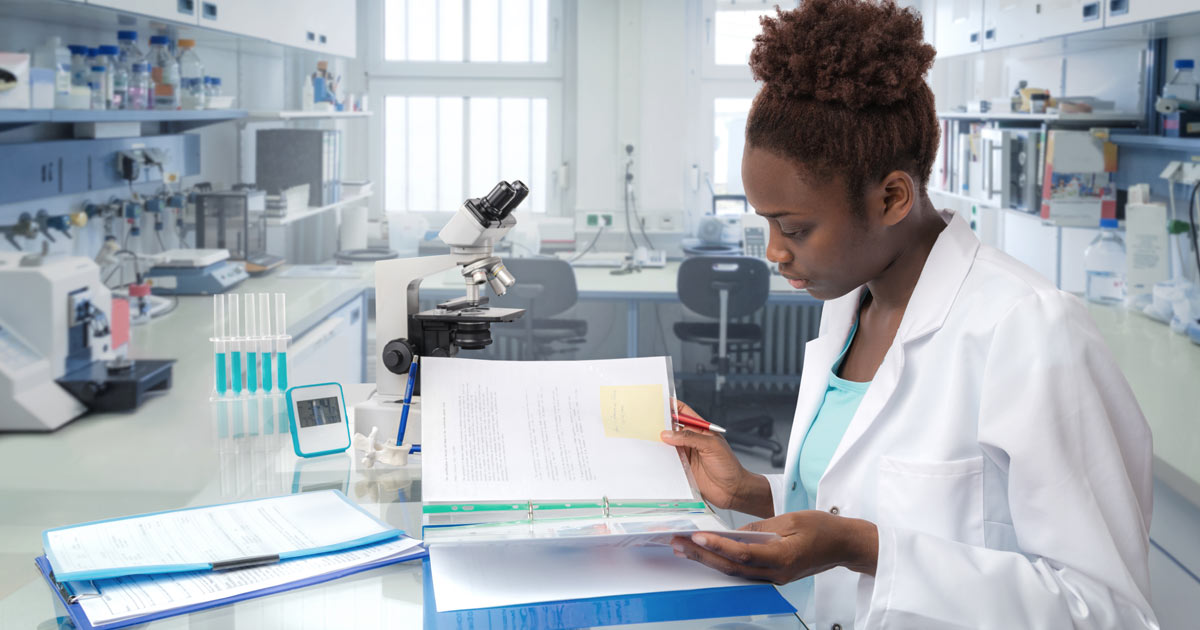 Biomed student reviews notes in lab