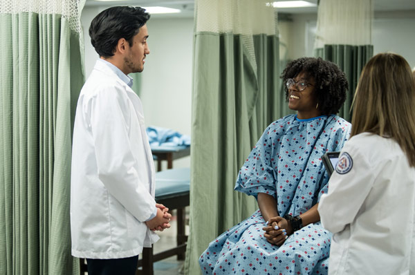 Two PCOM physician assistant students attend to a patient