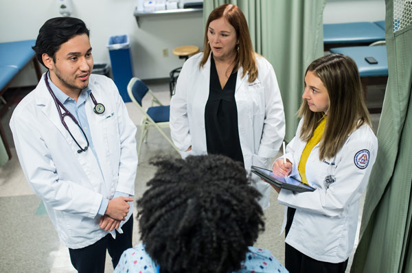 PA Studies students meet with a patient during rounds