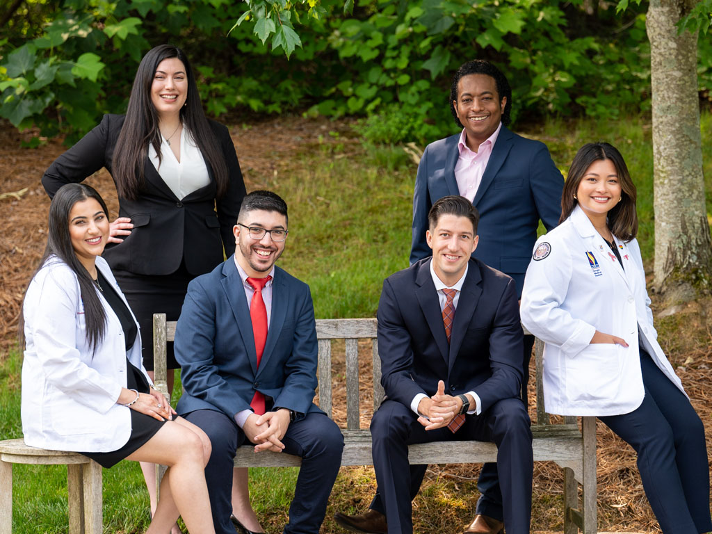 Group shot of PCOM Georgia students smiling on a bench