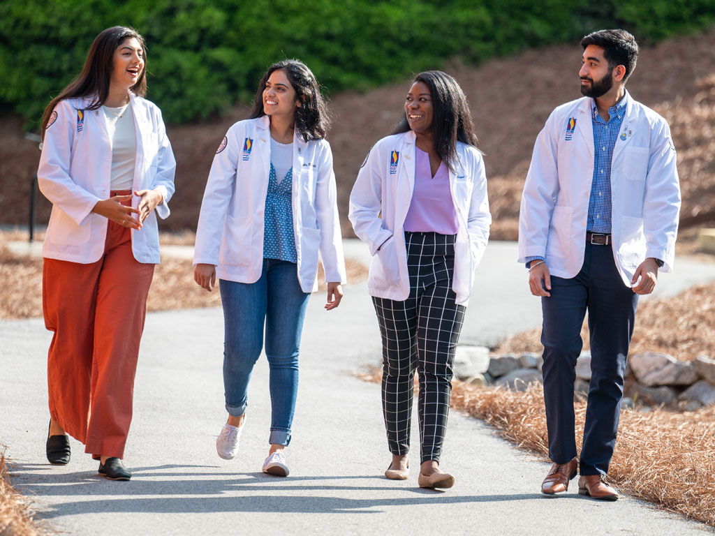 PCOM Georgia medical students walking and talking on a path outside