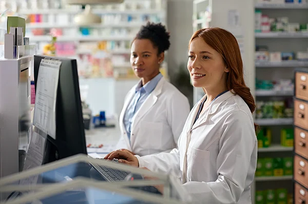 Two PCOM Georgia PharmD students use computers during a dispensing lab exercise