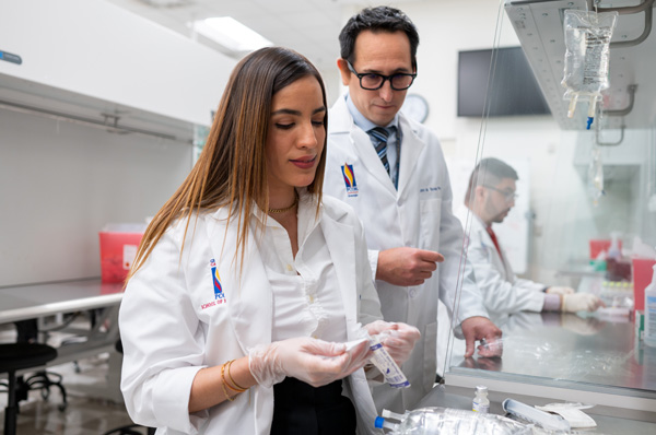 PCOM pharmacy student and faculty smile as they work in the lab