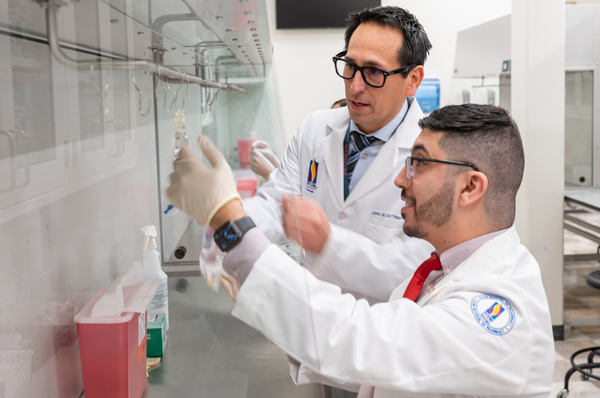 PCOM pharmacy student and faculty smile as they work in lab