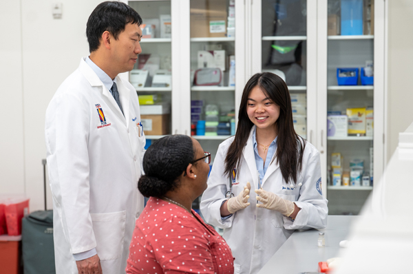 PCOM pharmacy student and faculty smile as they consult with each other