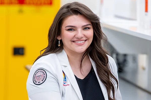 A PharmD student smiling in a PCOM Georgia pharmacy lab