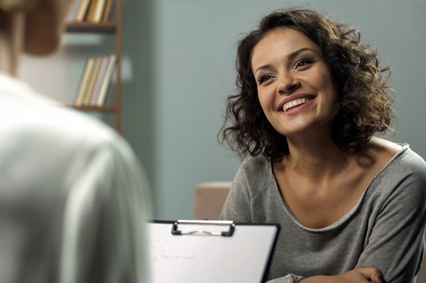 A smiling young woman patient during a positive psychology counseling session