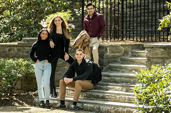 Clinical psychology students pose on steps in the campus courtyard
