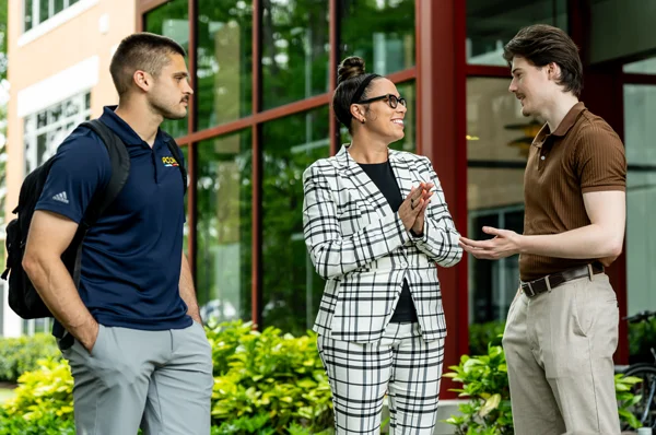 PCOM psychology students and faculty talk to guests during a campus tour event outside