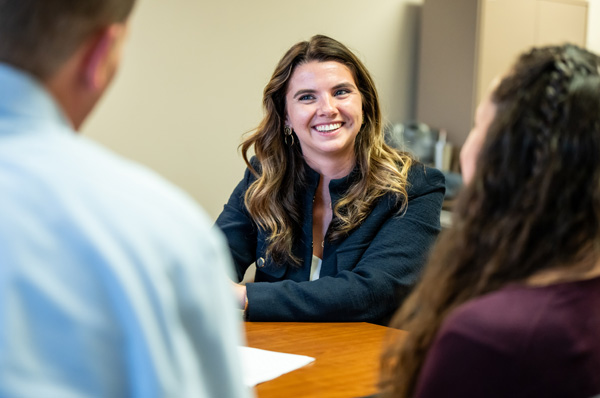 A PCOM school psychology student smiles while interacting with a psychology professional and a student during a career learning event