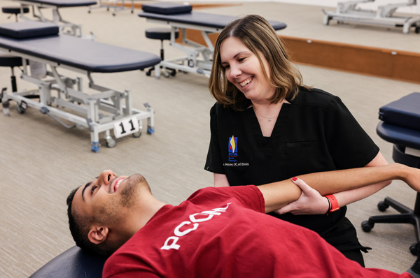 A faculty member teaches OMT techniques to PCOM medical students